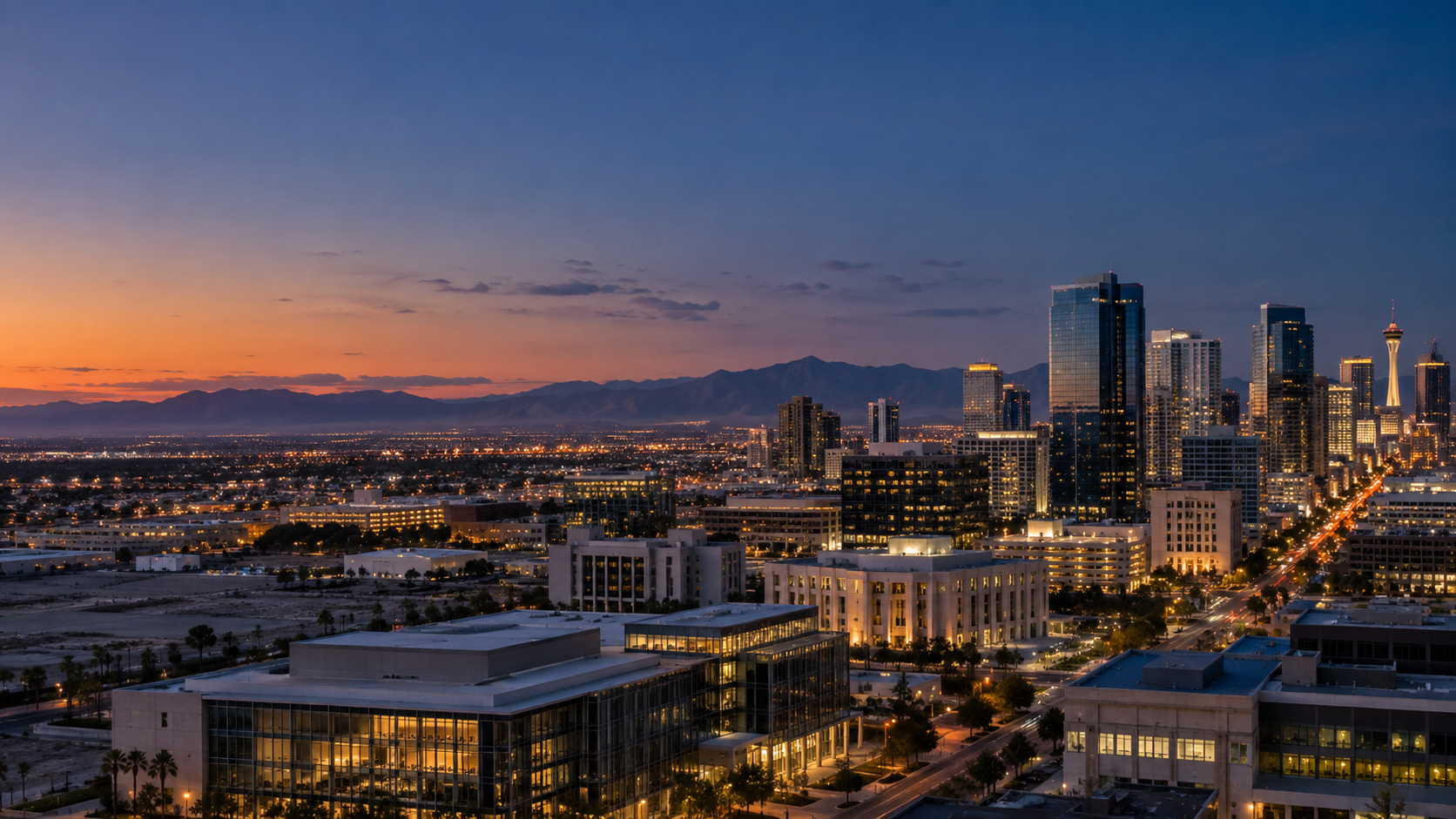 Las Vegas business district skyline and desert mountains at blue hour